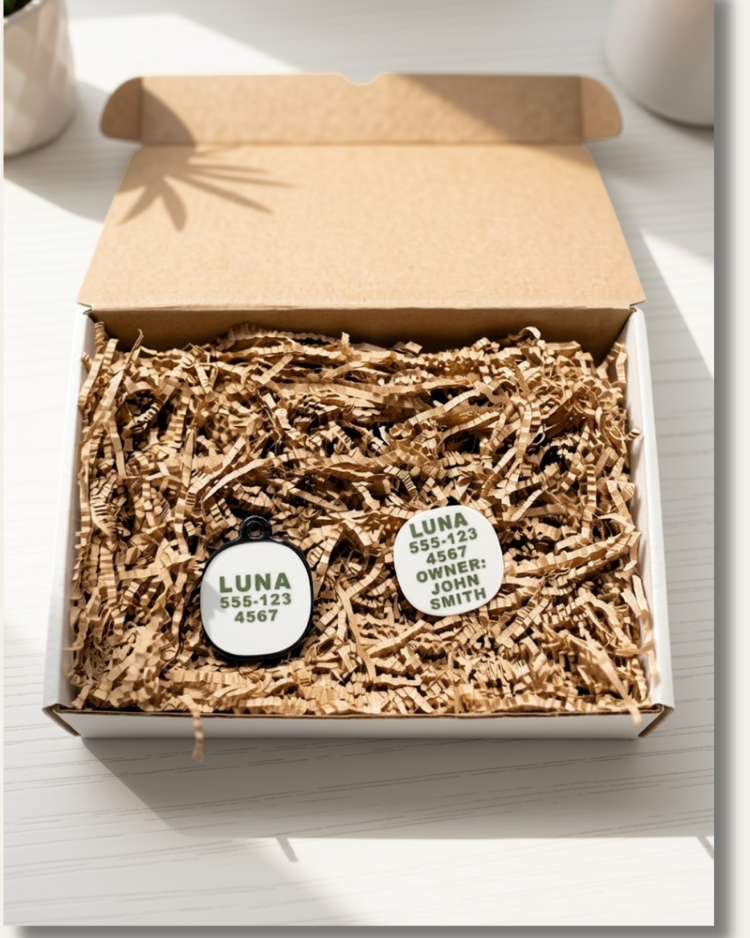 White and olive green AirTag holders personalized with pet name "Luna" and a phone number