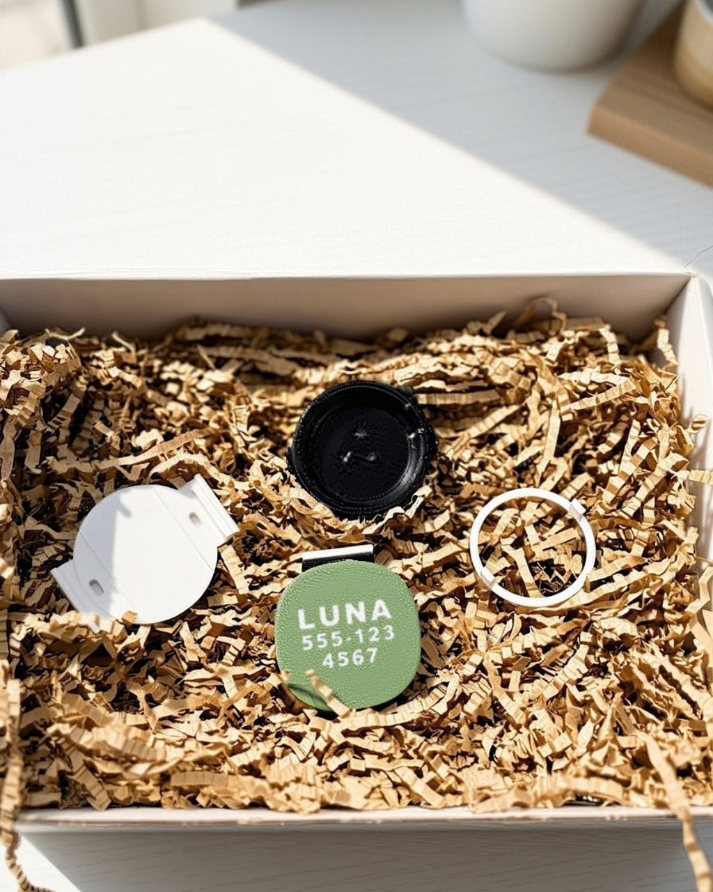AirTag holder parts: black TPU base, olive green personalized plate and ring